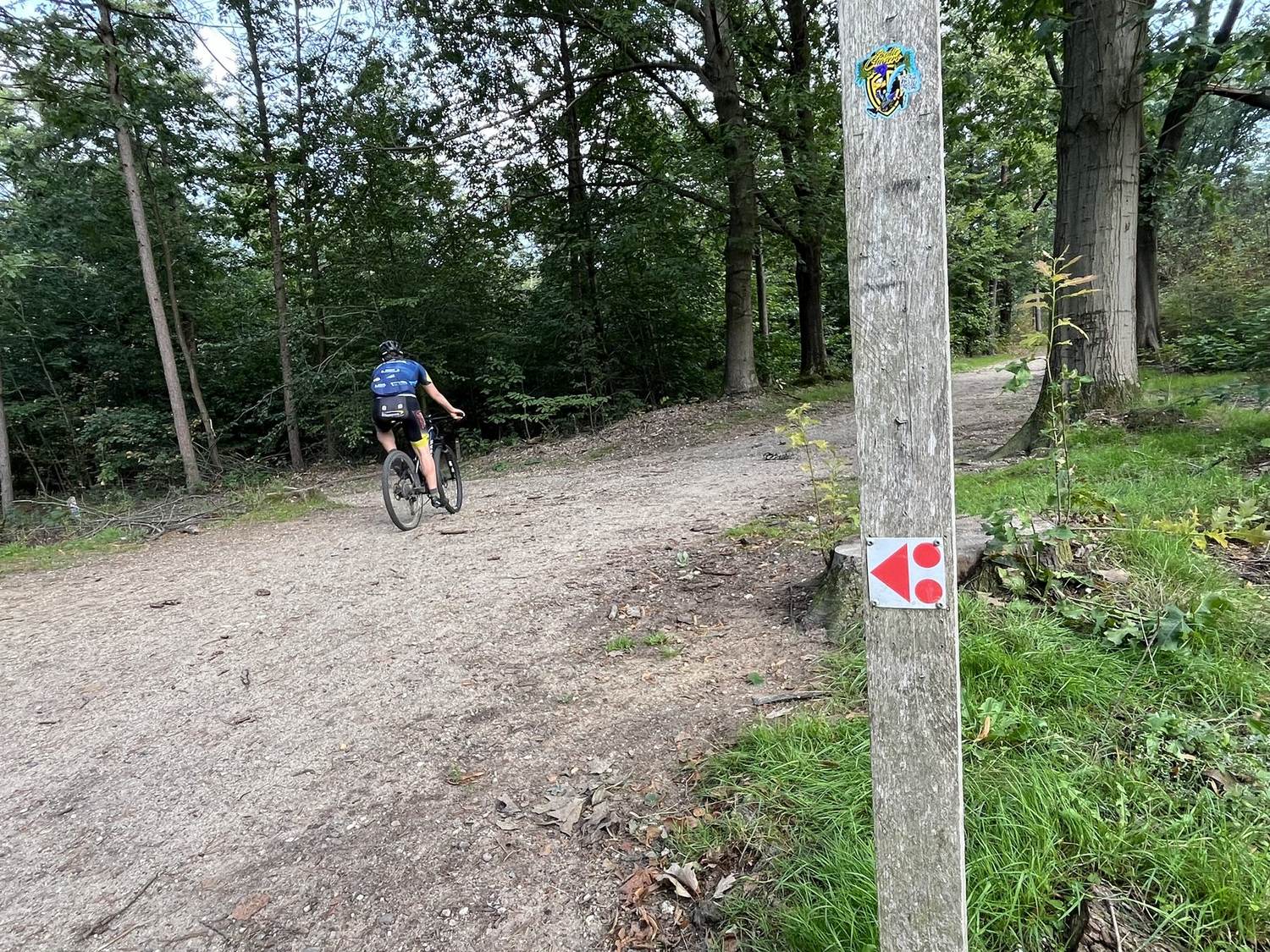 Rood routebordje van de TREK-route bij Nijmegen, met mountainbiker